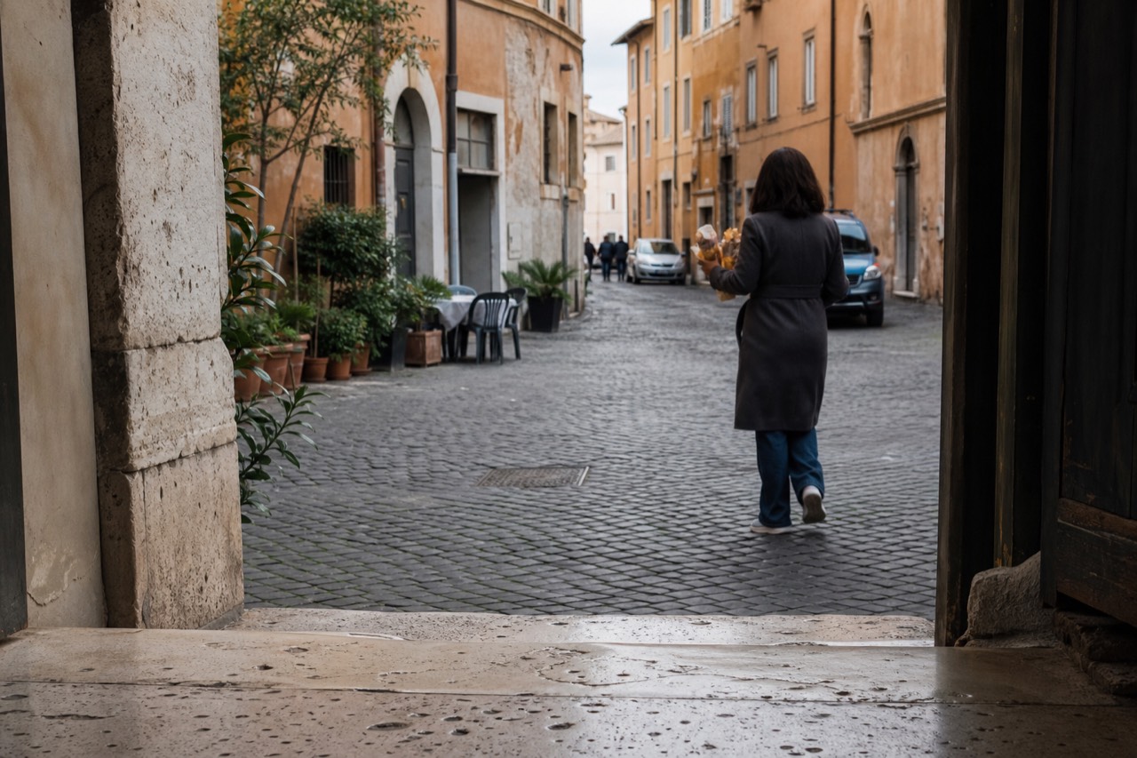 Under an overcast Rome sky in the Jewish Ghetto, a distant figure carries paper-wrapped fried artichokes down a cobbled street past cracked ocher walls