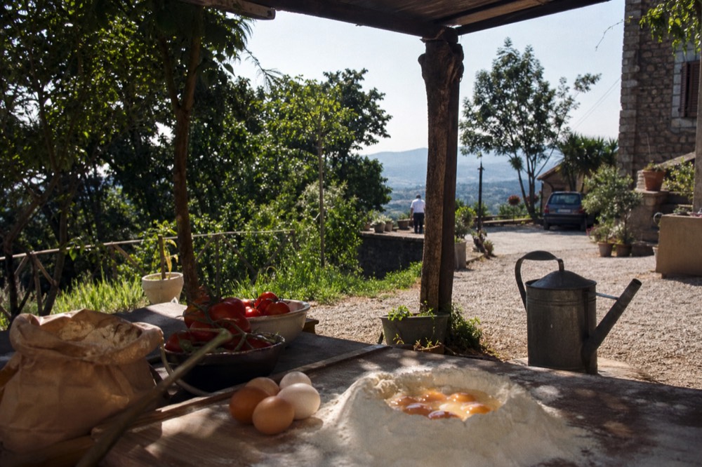 A sunny Italian courtyard table with ingredients for a pasta lesson