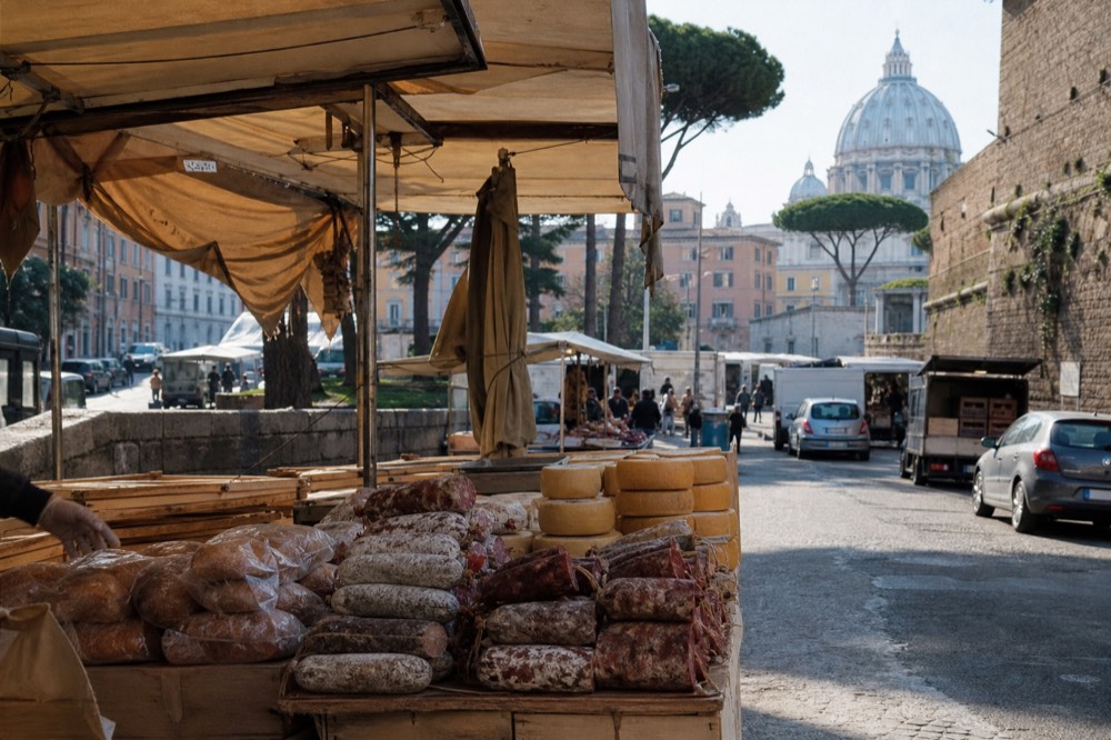 A market stall display of cured meats, cheeses and bread under a canopy