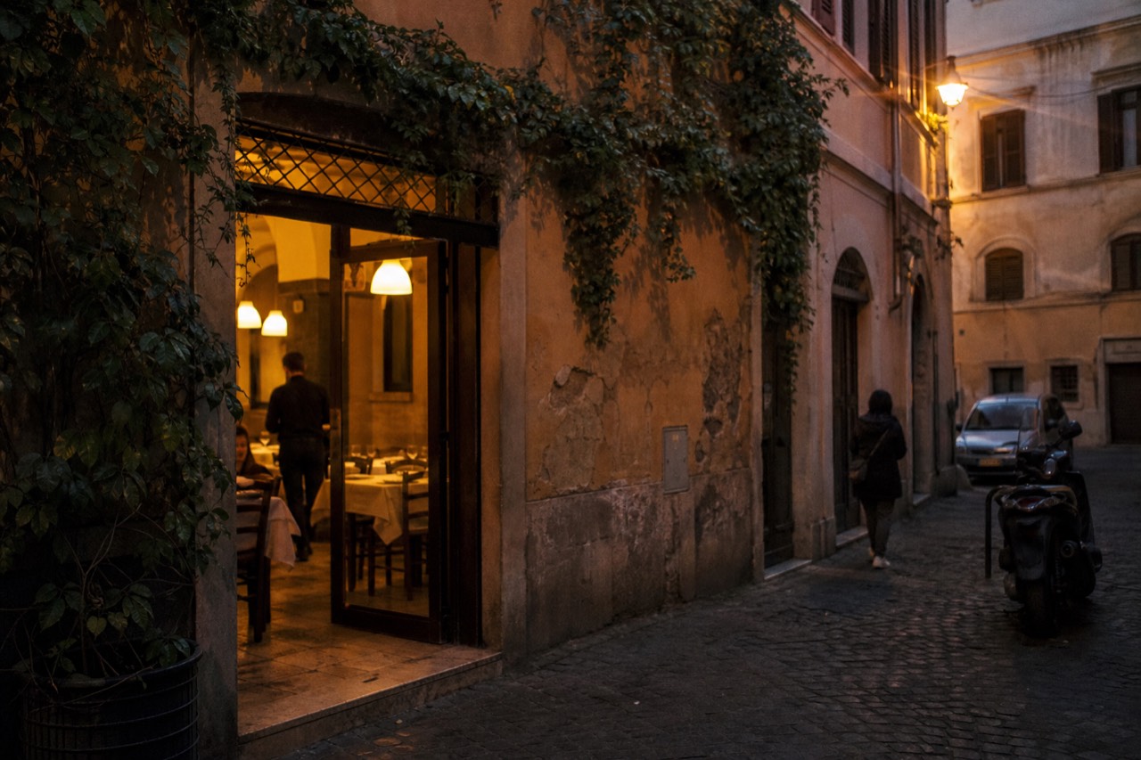 Chalkboard menu on a wall outside a small Roman trattoria
