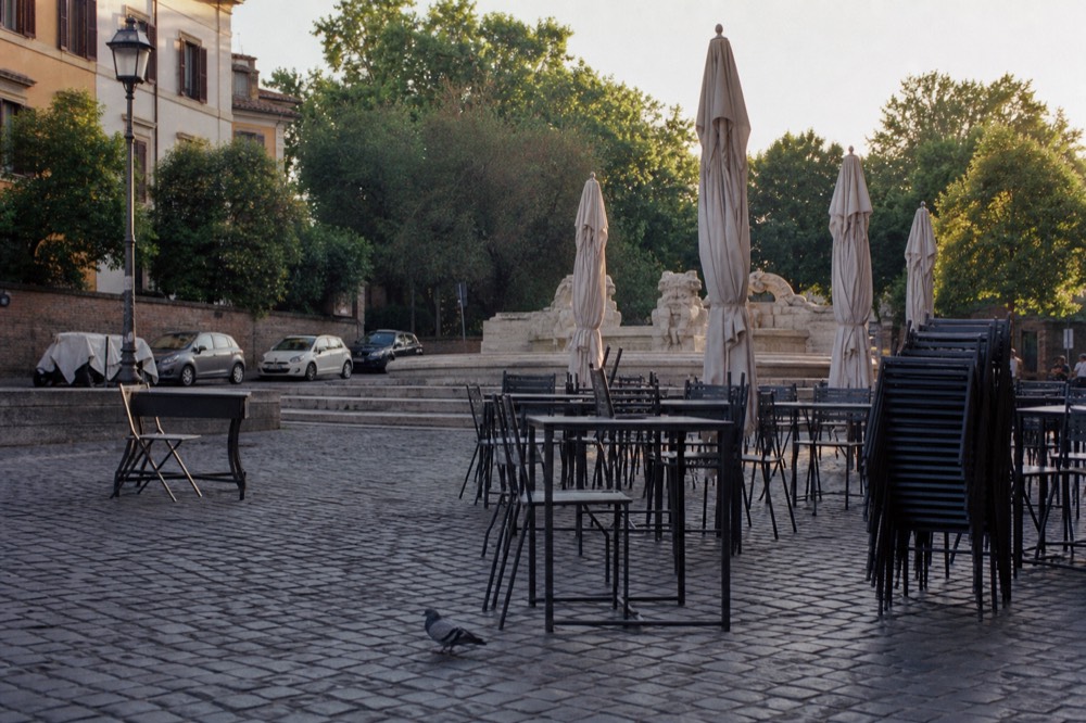 Empty restaurant tables in a Roman piazza in early evening before the dinner rush