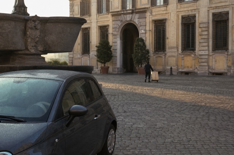 A small private vehicle parked on a quiet Roman street between food tour stops