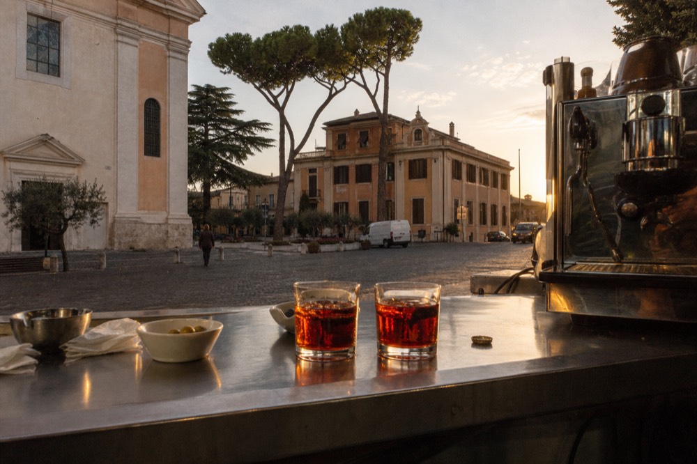 Bar counter with aperitivo glasses and small snack plates in warm evening light