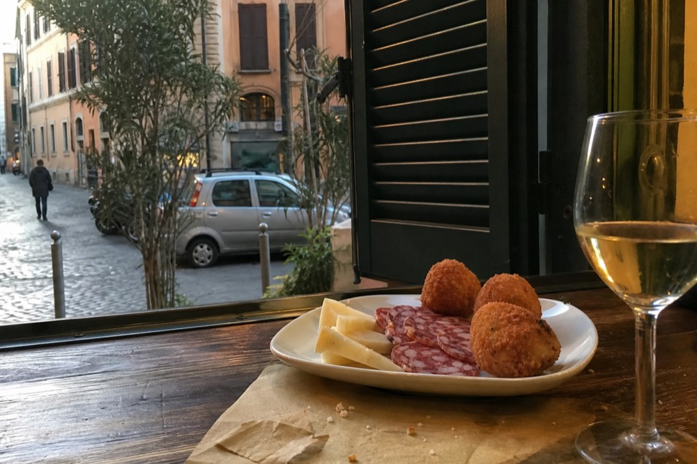 Platter of cured meats, cheese and fried snacks on a bar table