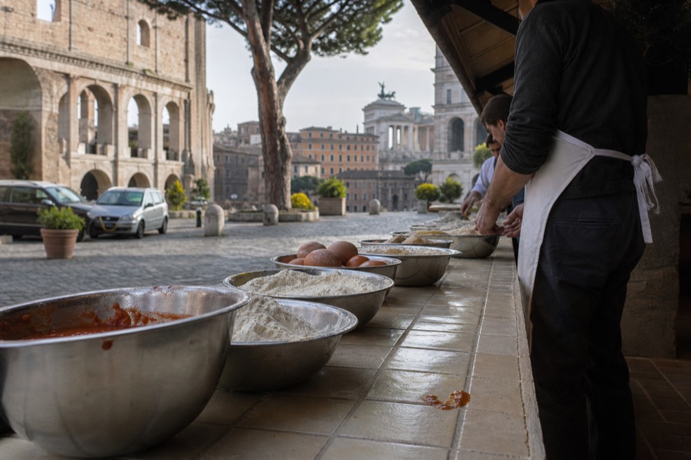 Family cooking class kitchen counter with bowls of flour, eggs and tomato sauce