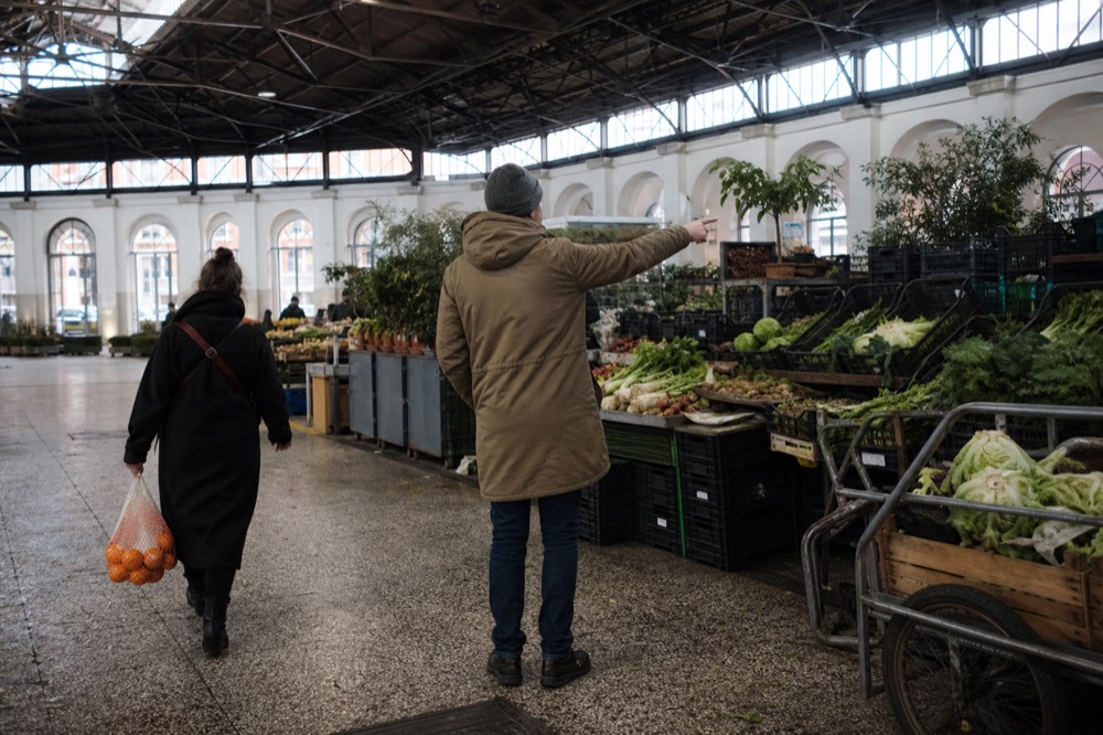 A guide pointing out stalls inside a covered Roman market hall
