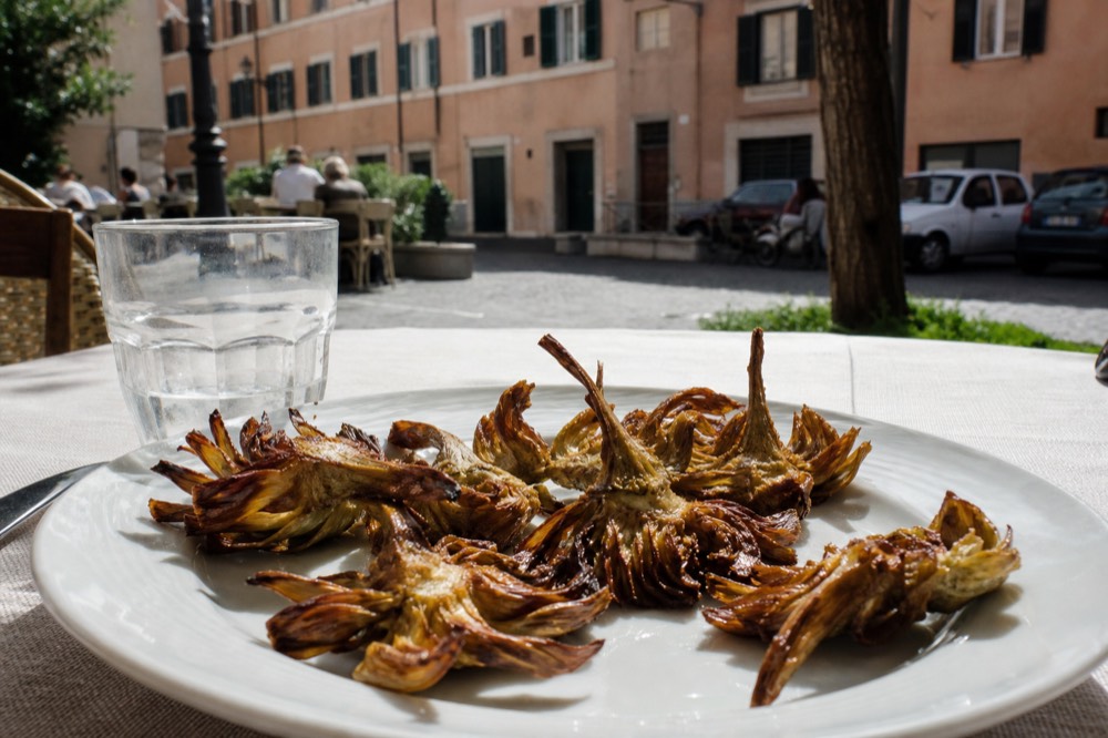 Golden fried artichokes served on a white plate in a Roman restaurant