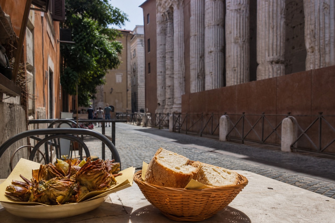 Fried artichokes and bread on a table beside a historic stone arcade in Rome