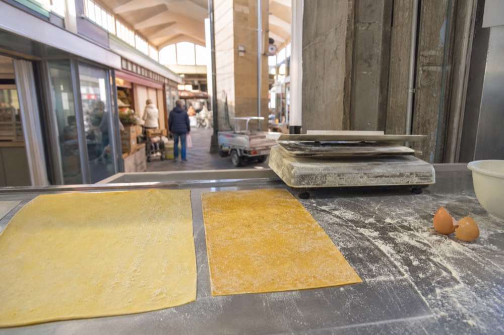 Fresh gluten-free and traditional pasta side by side on a market counter