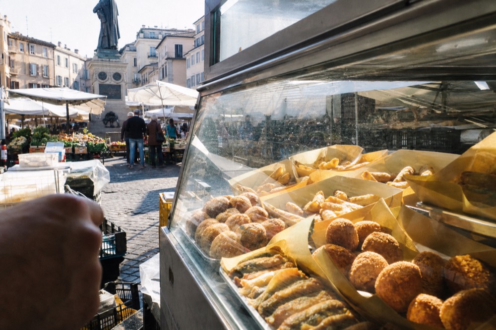 Street food stall in Rome with fried snacks displayed in a glass case