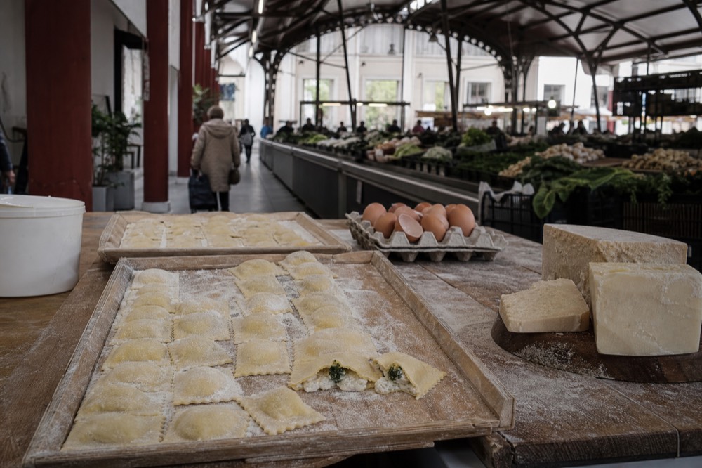 Fresh pasta shapes arranged on a wooden market counter