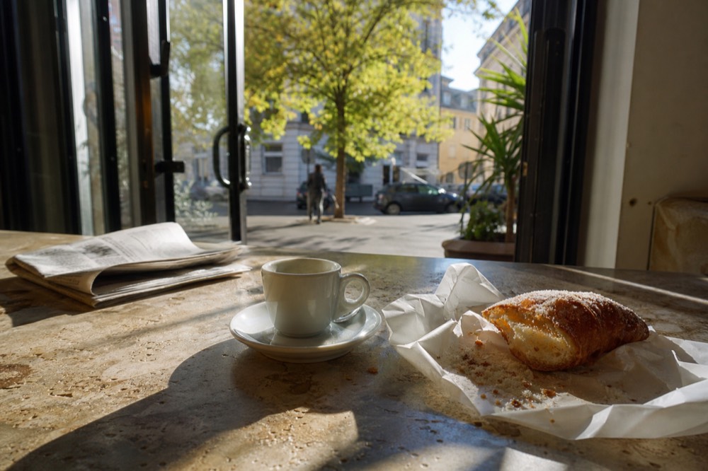 Espresso cup and cornetto on a marble cafe counter