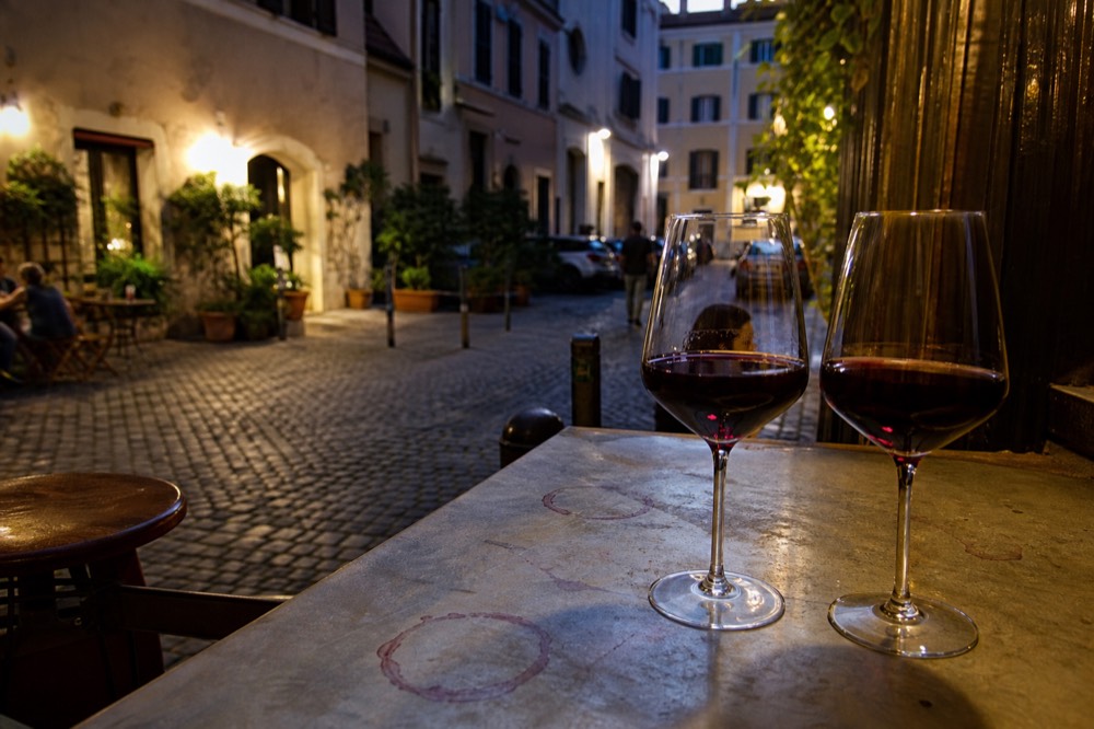 Glasses of red wine poured at a Trastevere tasting counter, no text, no logos, no people